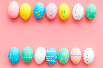 Easter composition. Decorated pastel Easter eggs on pink background top view space for text