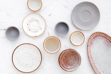 Kitchen concept. Crockery kit. Empty ceramic plates and mugs on white background top view