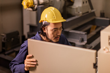 Young Asian engineer look at the controler machinery..