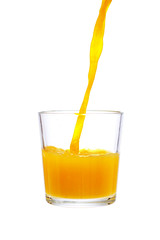 pouring orange juice in glass isolated on white background