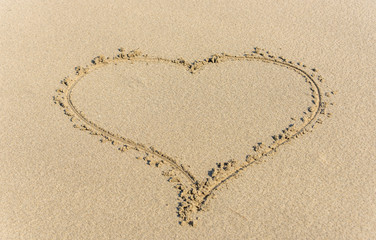 Fototapeta na wymiar Heart Drawn into the Sand on a Beach on a Sunny Day