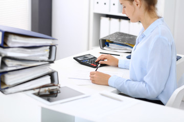 Fototapeta na wymiar Unknown female bookkeeper or financial inspector calculating or checking balance, making report, close-up. Internal Revenue Service at work with financial document. Tax and audit concept