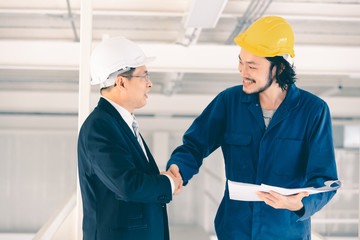 Asian engineer handshakes with executive engineer..