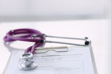 Medication history record form lying on table with stethoscope and silver pen. Medicine or pharmacy concept. Medical tools at doctor working table