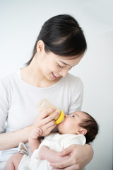 哺乳瓶で赤ちゃんに授乳させる女性