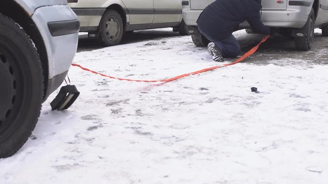 A man catches a towing cable on a car tug, winter, zvodka car using a tug, problem