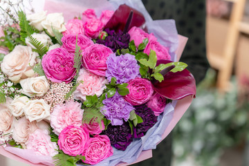 ombre of color. beautiful fresh cut bouquet of mixed flowers in woman hand. the work of the florist at a flower shop. Delicate Pastel tones color