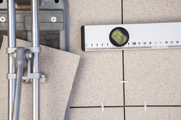 Tile cutter tool, spirit level, porcelain for floor installing, background