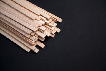 Pile of miniature wooden planks on dark background