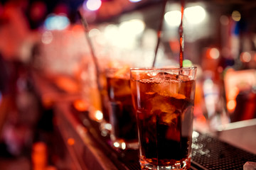 Expert barman is making cocktail at night club.