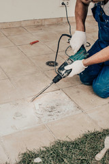 Men worker are extracting, drilling tiles with perforator, selective focus