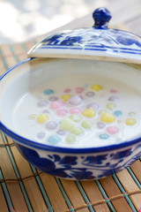 Color of Rice Dumpling in Coconut Milk (Bua Loy) in white bowl on wooden table for served in party. Famous dessert in Thailand. Sweet and delicious food.