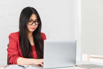 Business woman sitting and working with a notebook on the front.