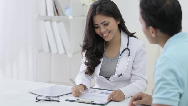 beautiful female doctor talk to her patient about some prescription