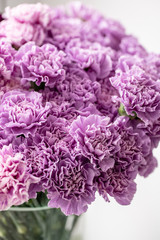 beautiful carnations flowers in a vase on a table . Bouquet of dark violet, purple and pink multicolor flower. Decoration of home. Floral texture, Wallpaper.