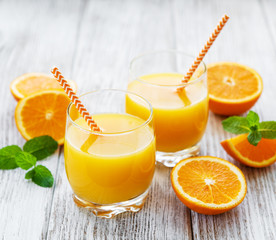 Glasses of juice and orange fruits