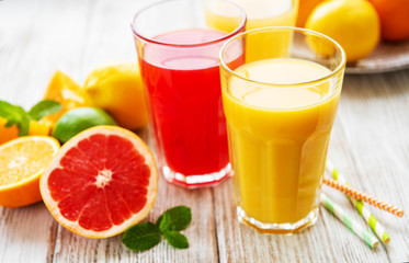 Glasses of juice and citrus fruits