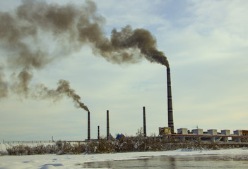 pipes of the enterprise pollute the air with black smoke