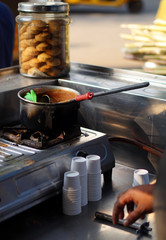 Indian street food vendor make tea beverage, on road side,outdoors,on a cart 