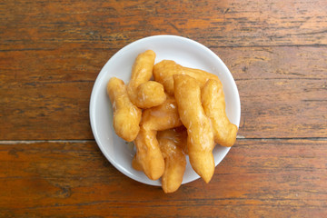 Thai deep-fried dough sticks served on white dish as breakfast.