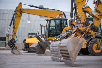 Multiple cars, excavators, trucks, loaders, concrete mixers and construction machinery in large...