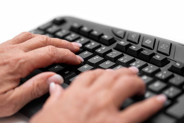 Seniorin beim Lernen vom Zehnfingersystem an der Tastatur