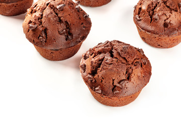 A closeup of chocolate muffins on a white background with copy space