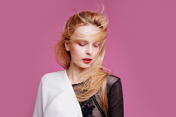 Fototapeta premium Blonde young woman in elegant body. Girl posing on a pink background. Make -up and hairstyle. Fashion photo