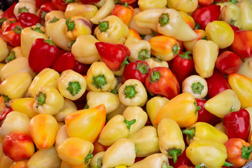 Red and yellow sweet peppers on counter in market
