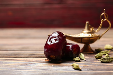 Aladdin lamp and dates on wooden table