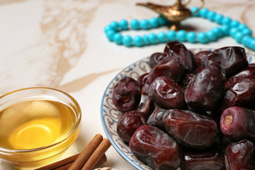 Tasty dates and honey on light background