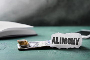 Money and paper with text ALIMONY on table