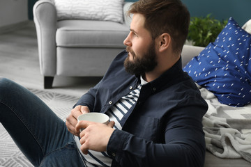 Bearded man drinking coffee at home