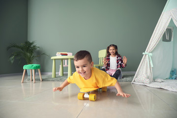 Cute little boy with skateboard at home