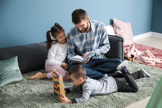 Young father with his children playing at home