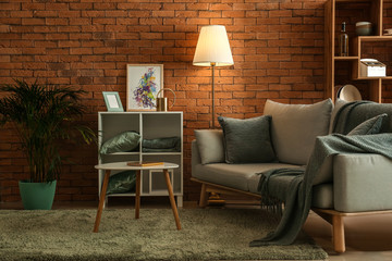 Stylish interior of room with comfortable sofa ad table