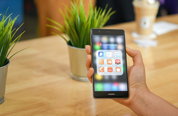 CHIANG MAI, THAILAND - JANUARY. 16,2019: Man holding HUAWEI with icons of E-commerce and online shopping on screen.smartphone lifestyle,e-commerce app concept.