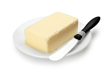 Plate with butter and knife on white background