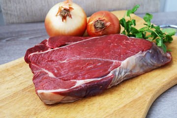 Fresh raw beef steak  on wooden background, top view 