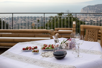 Fototapeta na wymiar Prepared for supper table on the terrace overlooking the Bay of Naples and Vesuvius. Sorrento. Italy