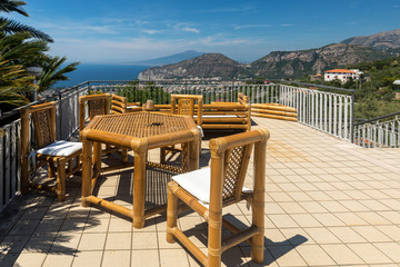 Fototapeta na wymiar Chairs and table on the terrace overlooking the Bay of Naples and Vesuvius. Sorrento. Italy