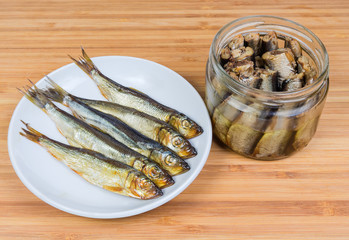 Smoked baltic herring on saucer and preserved in oil