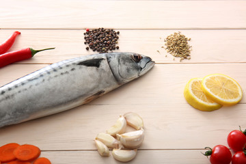 Tasty raw mackerel fish with ingredients on white table