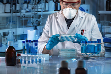 geneticist holding multi well plate for genetic analytical in the clinical laboratory / Technician working with biological samples in genetical lab