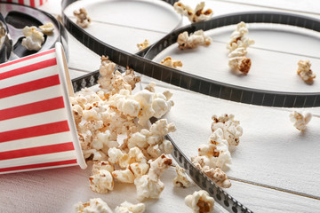 Tasty popcorn and film on wooden background