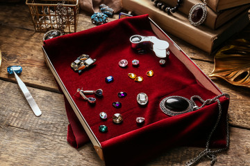 Box with beautiful adornments and gemstones on table