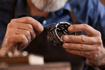 Jeweller making beautiful bracelet in workshop, closeup