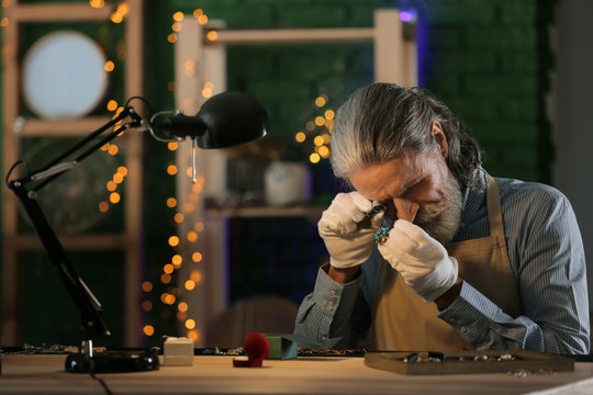 Jeweller examining adornment in workshop