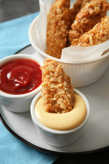 Tasty nuggets with sauces on table, closeup