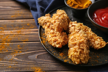 Plate with tasty nuggets on wooden table